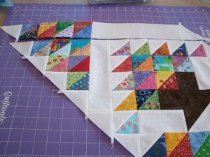 Sew four HSTs together and add a white triangle at one end. Sew the 2.5" x 10.5" white strip to the HST's and finish with another white triangle. Sew this strip to the RIGHT side of the basket block. 